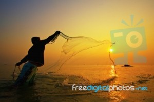 throwing-fishing-net-during-sunset-10080343